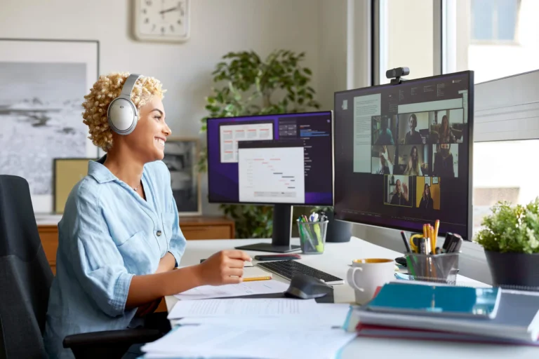 woman with headphones in online meeting with multilpe screens